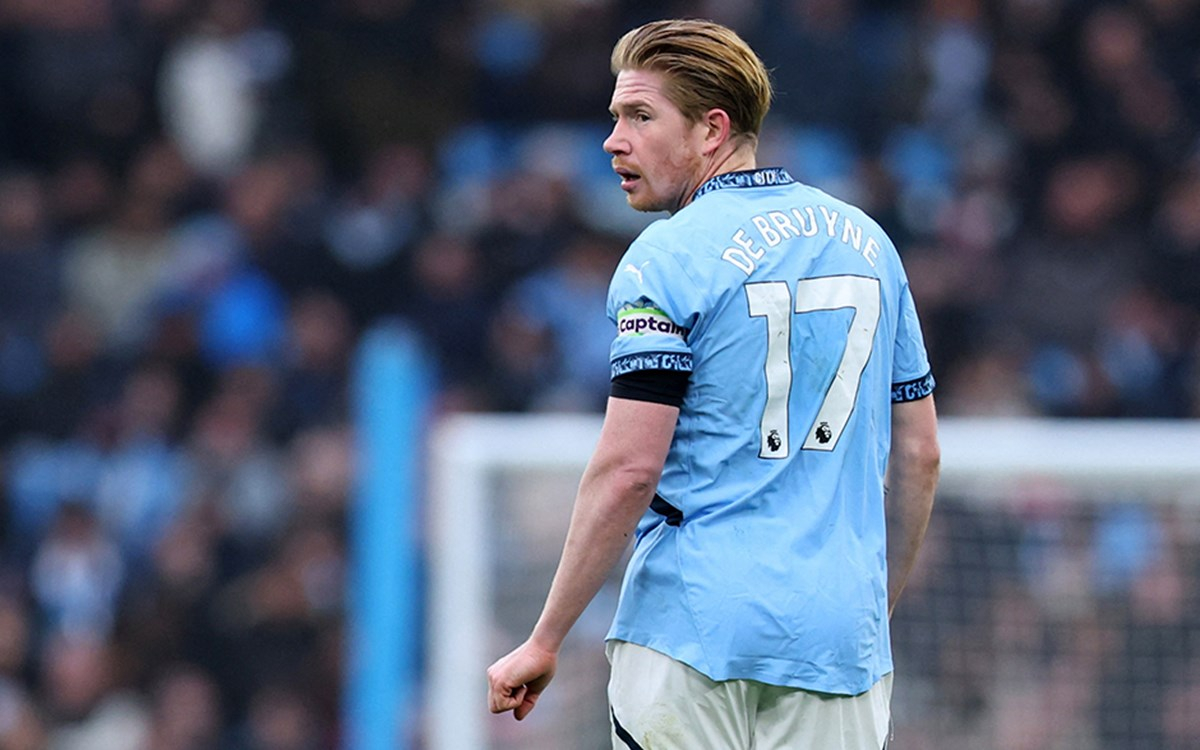 Kevin De Bruyne Napoli'ye transfer oluyor, futbol köşesinde poz verirken.